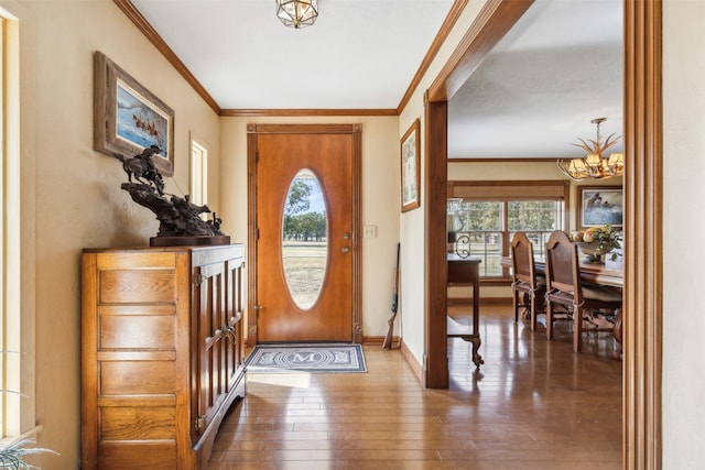 foyer featuring an inviting chandelier, wood-type flooring, and crown molding