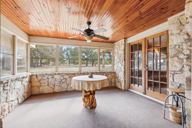 unfurnished sunroom featuring wood ceiling and ceiling fan