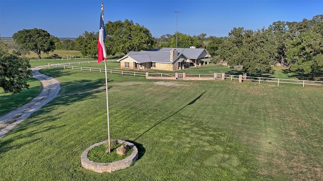 view of community featuring a lawn and a rural view