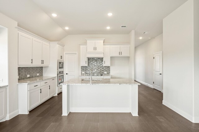 kitchen featuring backsplash, a kitchen island with sink, white cabinets, and stainless steel appliances