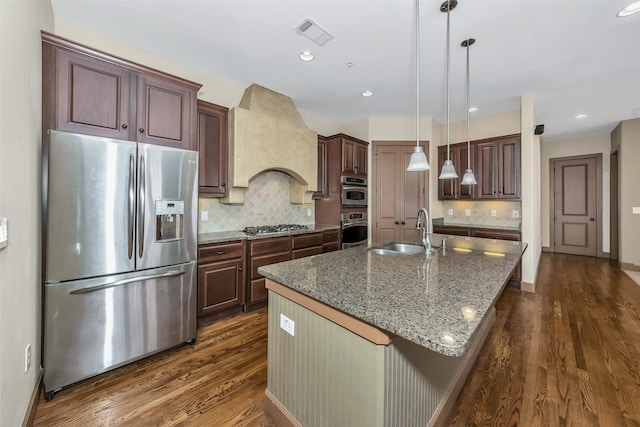 kitchen featuring custom range hood, stainless steel appliances, dark hardwood / wood-style flooring, sink, and a center island with sink