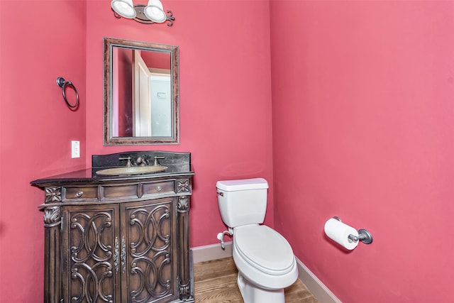 bathroom with hardwood / wood-style floors, toilet, and vanity