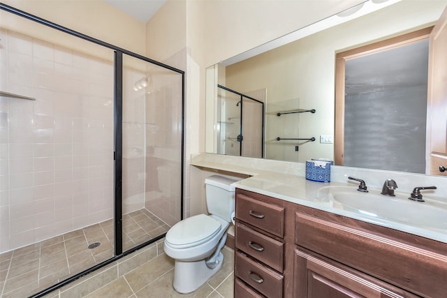 bathroom featuring tile patterned flooring, vanity, toilet, and a shower with shower door