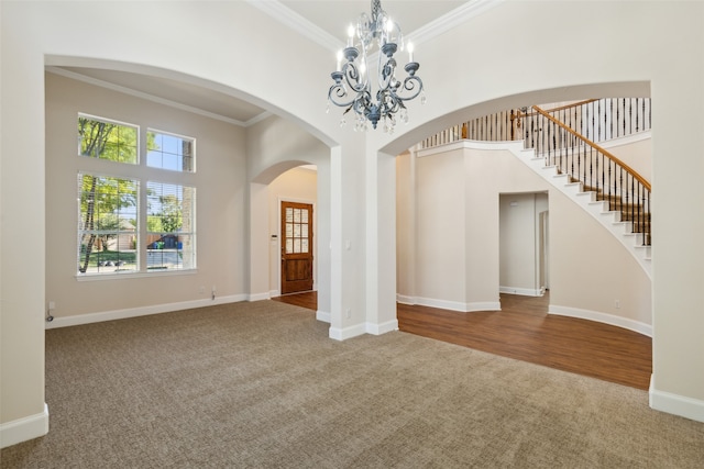 empty room with an inviting chandelier, crown molding, and carpet flooring