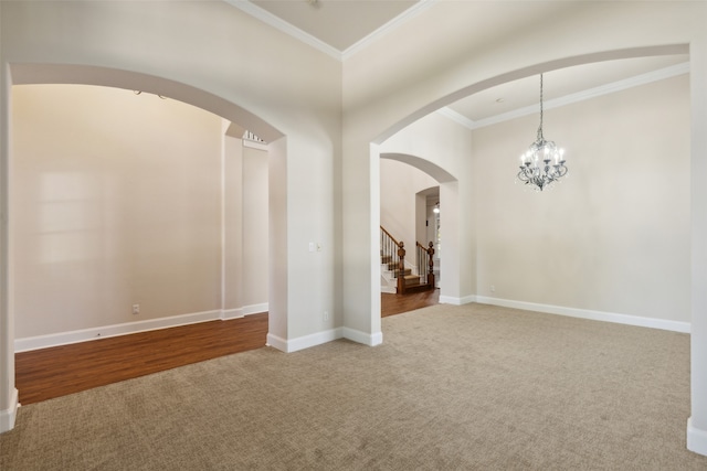 spare room with ornamental molding, hardwood / wood-style floors, and a notable chandelier