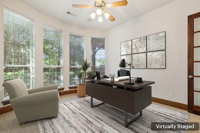 carpeted office space with a healthy amount of sunlight and ceiling fan