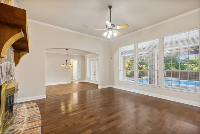 unfurnished living room with crown molding, dark hardwood / wood-style flooring, ceiling fan, and a brick fireplace