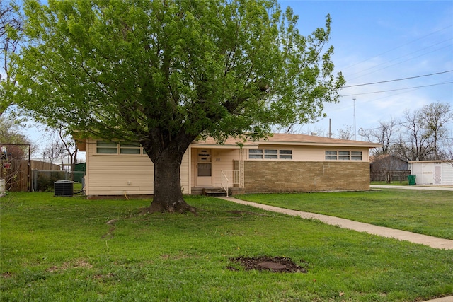 ranch-style house featuring central AC unit and a front lawn