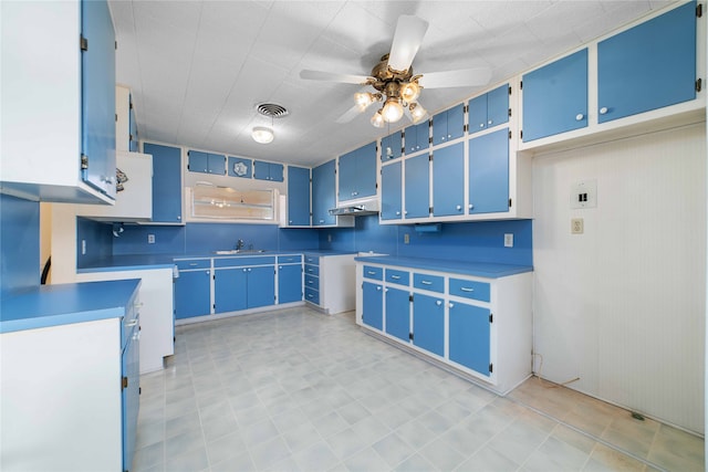 kitchen featuring ceiling fan, blue cabinetry, and sink