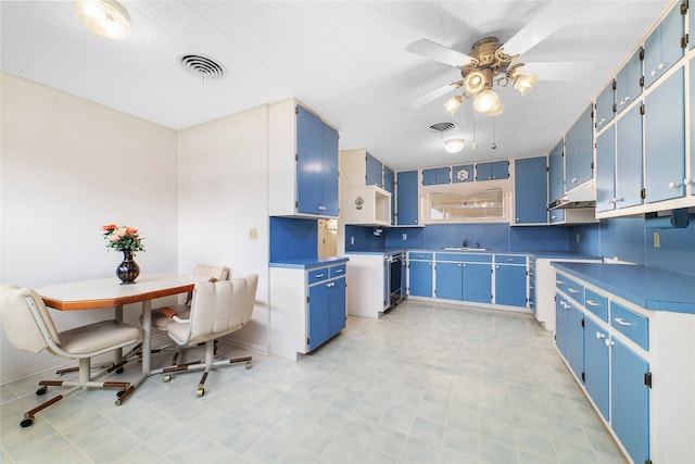 kitchen with blue cabinets, sink, and ceiling fan