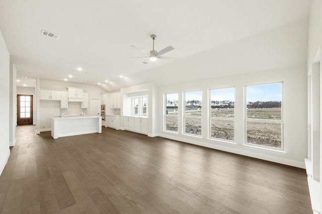 unfurnished living room featuring ceiling fan, plenty of natural light, dark hardwood / wood-style flooring, and lofted ceiling