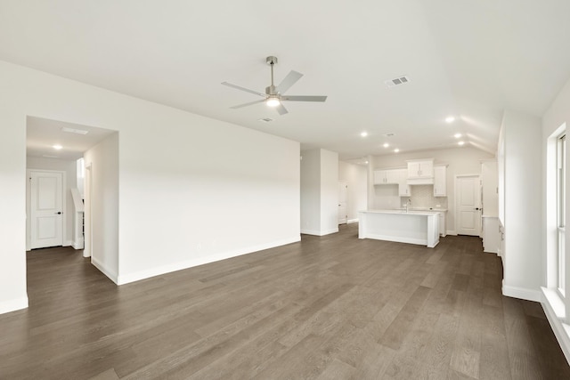 unfurnished living room with dark wood-type flooring and ceiling fan