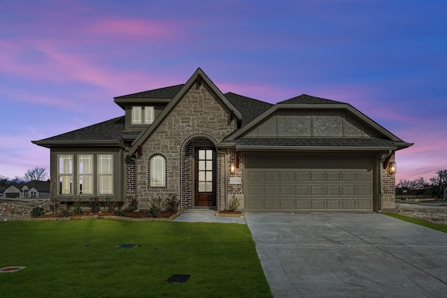 view of front of property featuring a lawn and a garage