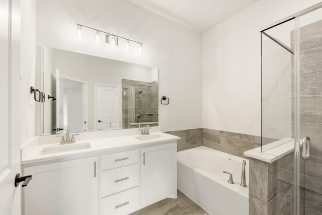 bathroom featuring vanity and independent shower and bath