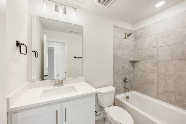 full bathroom featuring tiled shower / bath combo, vanity, and toilet