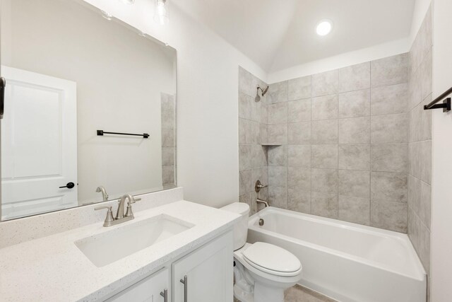 full bathroom with toilet, vanity, lofted ceiling, and tiled shower / bath combo