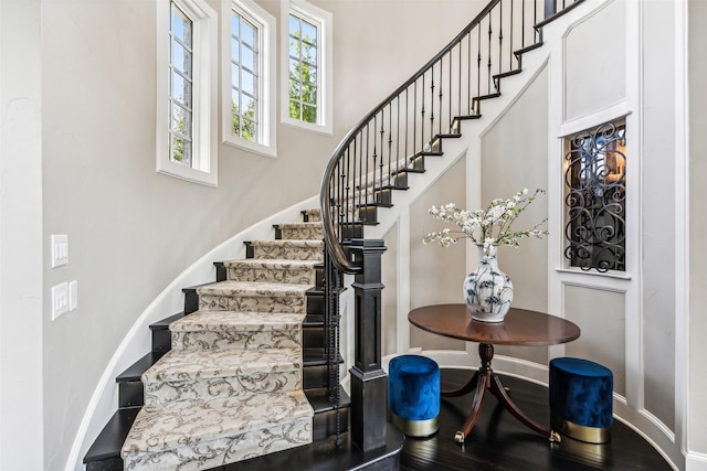 stairs with a towering ceiling and baseboards