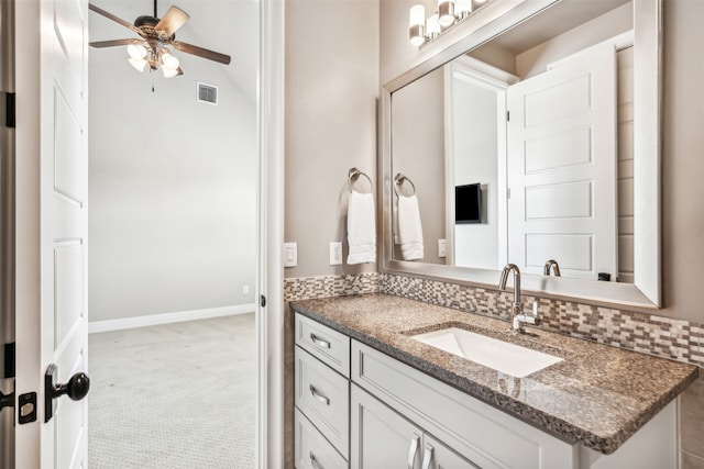 bathroom with ceiling fan, vanity, and tasteful backsplash