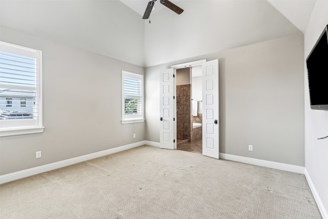 unfurnished bedroom featuring ceiling fan, ensuite bathroom, and light carpet