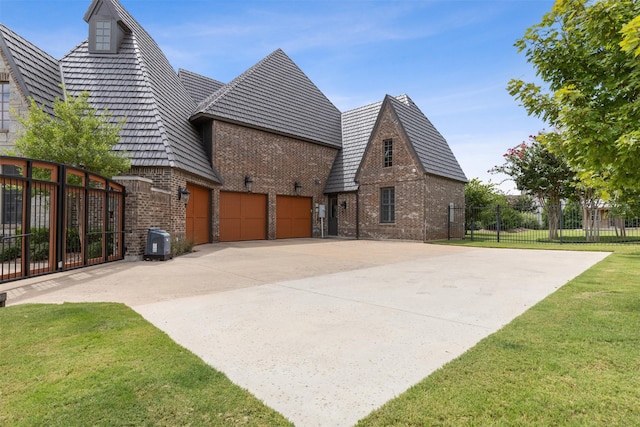 view of side of home with fence, concrete driveway, a lawn, central AC, and brick siding