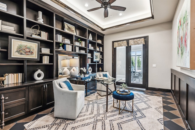 sitting room with ceiling fan and a tray ceiling