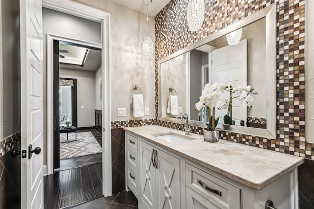 bathroom with vanity, tile walls, tile patterned floors, and tasteful backsplash