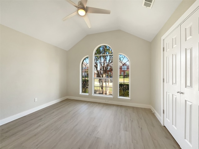 unfurnished bedroom with a closet, ceiling fan, light hardwood / wood-style floors, and vaulted ceiling