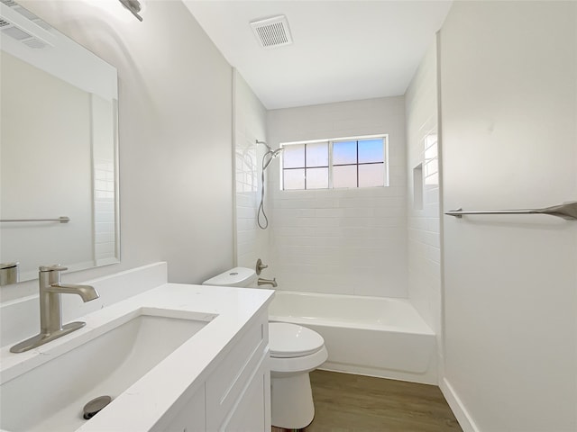 full bathroom featuring tiled shower / bath, toilet, wood-type flooring, and vanity