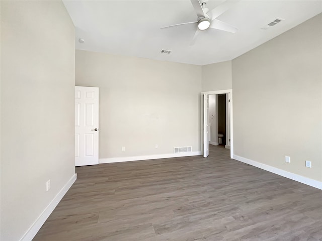 unfurnished room featuring dark wood-type flooring and ceiling fan