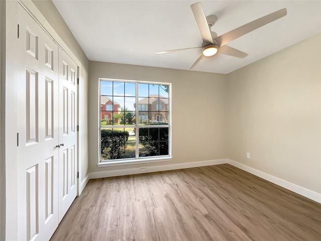 spare room featuring a wealth of natural light, ceiling fan, and light hardwood / wood-style floors