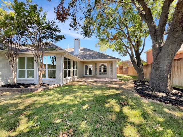 back of house with a yard and a patio