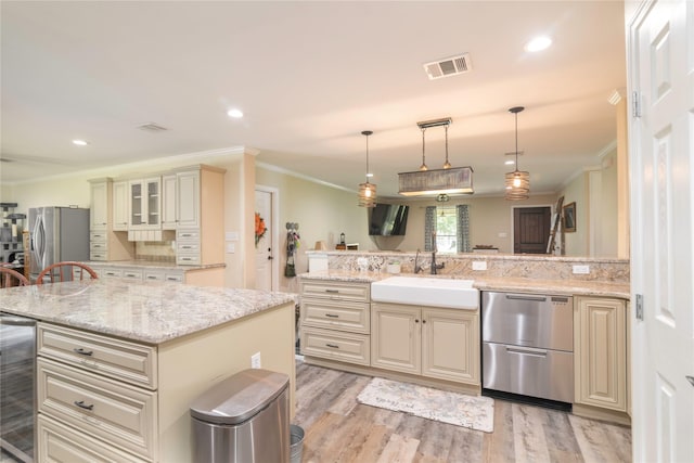 kitchen featuring visible vents, cream cabinets, light wood-style floors, stainless steel refrigerator with ice dispenser, and a sink