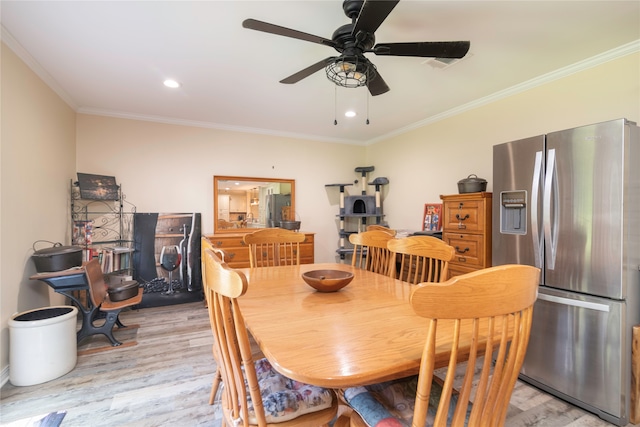 dining space with light wood-type flooring, ceiling fan, and ornamental molding