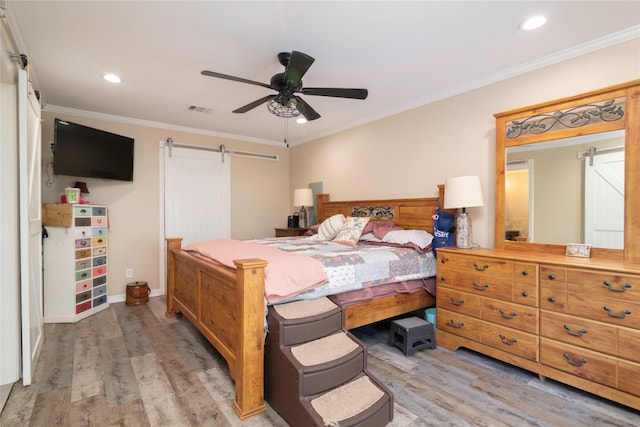 bedroom featuring crown molding, a barn door, ceiling fan, and light wood-type flooring