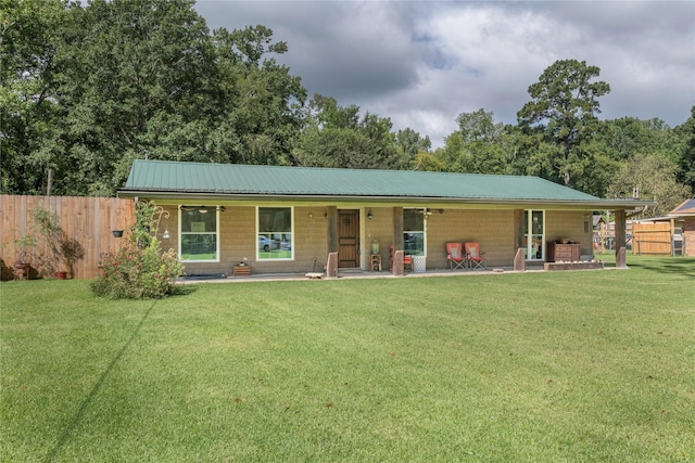 view of front of property with a front yard, fence, and metal roof