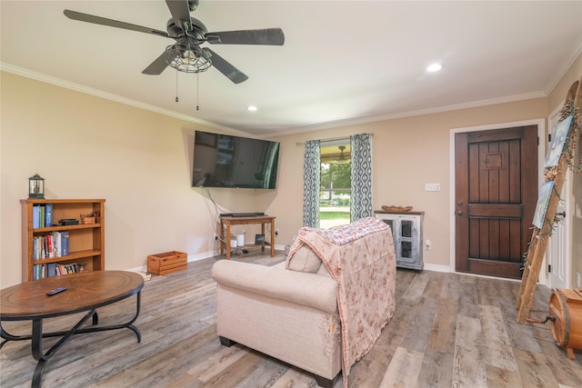 living room with crown molding, ceiling fan, and light hardwood / wood-style floors