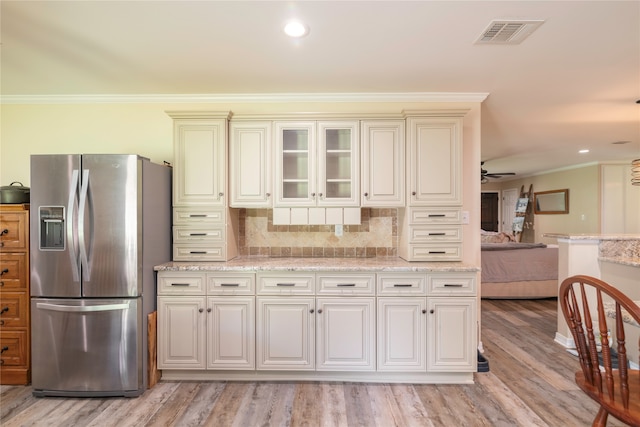 kitchen with light wood-type flooring, ceiling fan, stainless steel fridge with ice dispenser, and ornamental molding