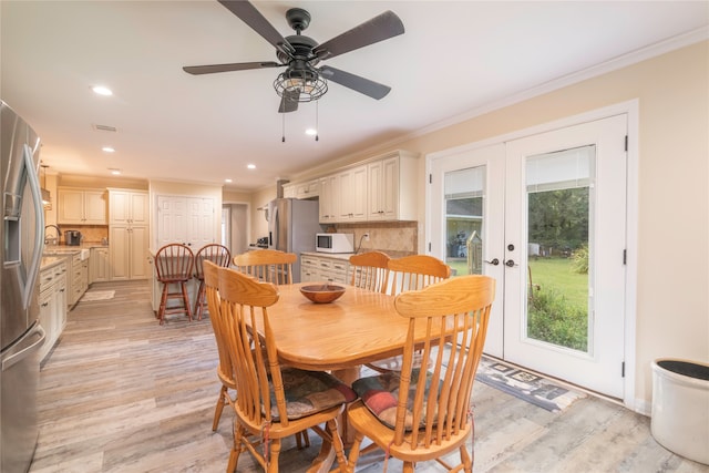 dining space featuring crown molding, ceiling fan, french doors, and light hardwood / wood-style floors