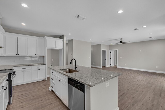 kitchen with an island with sink, sink, ceiling fan, appliances with stainless steel finishes, and white cabinets