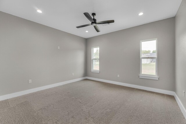 carpeted empty room with a wealth of natural light and ceiling fan