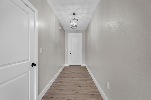 hall featuring a chandelier and light hardwood / wood-style floors