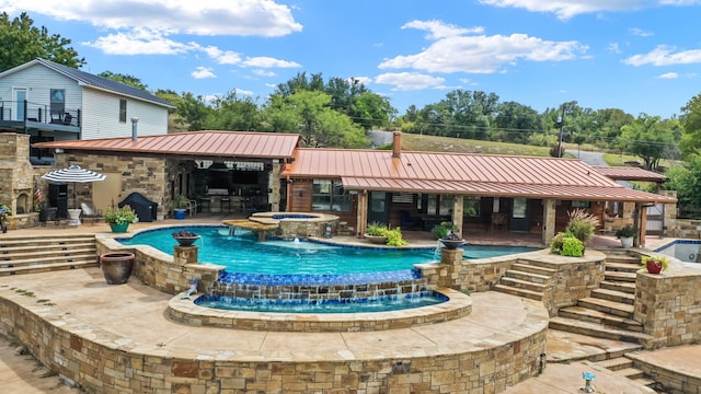 view of swimming pool with a patio area, an in ground hot tub, and pool water feature