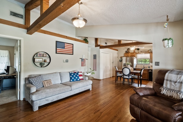 living room with lofted ceiling with beams, a textured ceiling, wood-type flooring, and ceiling fan