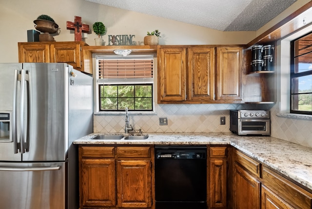 kitchen with vaulted ceiling, dishwasher, backsplash, stainless steel fridge with ice dispenser, and sink