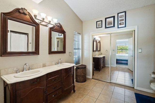 bathroom with vanity, a textured ceiling, toilet, and tile patterned floors