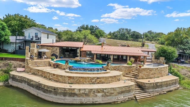 back of property featuring a pool with hot tub, a water view, and a patio area