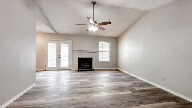 unfurnished living room featuring ceiling fan, wood-type flooring, a textured ceiling, vaulted ceiling, and a fireplace