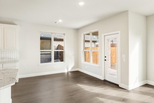 unfurnished dining area featuring dark hardwood / wood-style floors