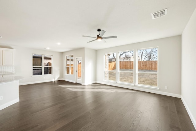 unfurnished living room featuring dark wood-type flooring and ceiling fan