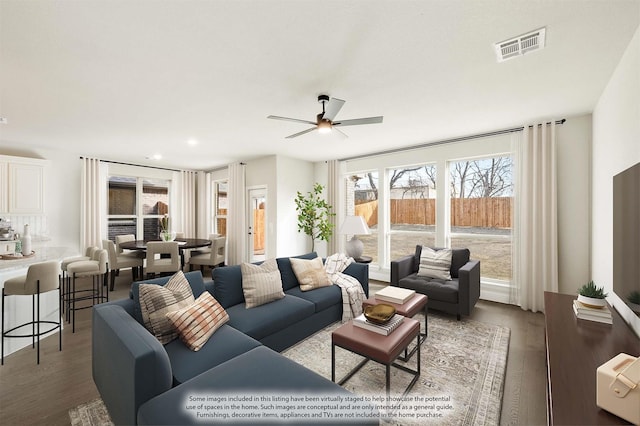 living room featuring ceiling fan and dark wood-type flooring